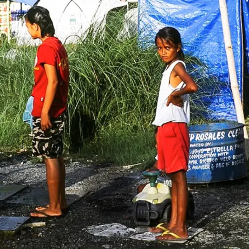 A mother and her daughter waiting for fresh water at a camp for refugees whose homes were destroyed by Typhoon Ondoy in September 2009. 